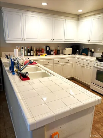 a kitchen with stainless steel appliances granite countertop a sink and white cabinets