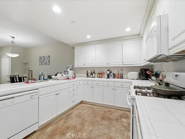 a kitchen with stainless steel appliances granite countertop white cabinets and a stove top oven