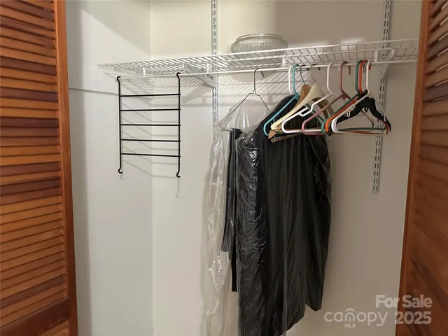 a view of walk in closet with clothes