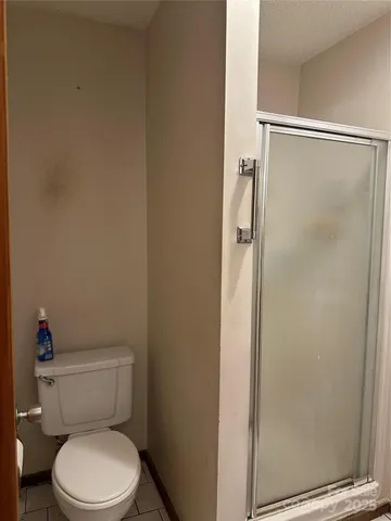 a white toilet sitting next to a shower