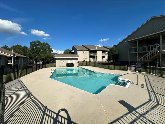a view of a patio with table and chairs with wooden floor and fence