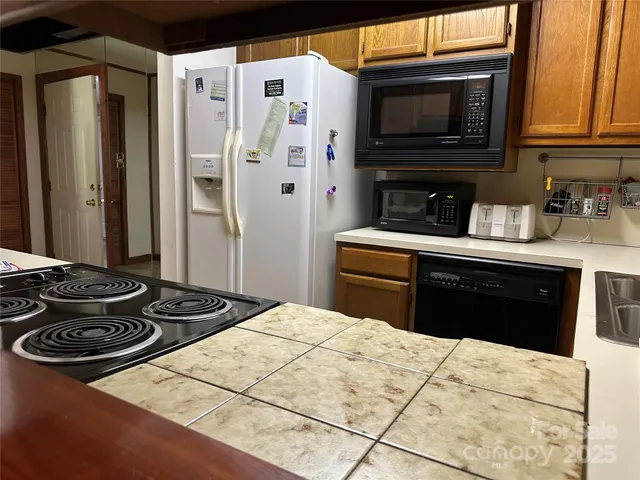 a kitchen with stainless steel appliances granite countertop a stove a refrigerator and a microwave