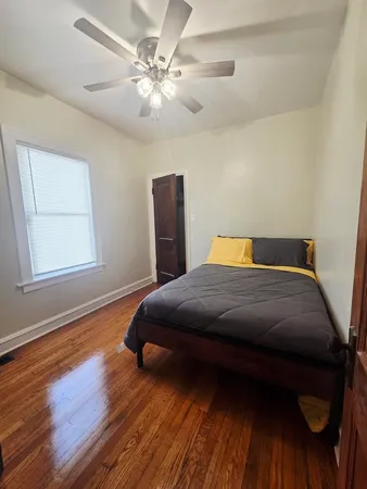 a bedroom with a bed and wooden floor
