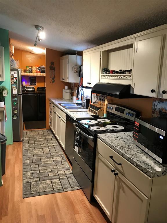 1192 Chobee Street Okeechobee, FL 34974 - Photo 3 of 18 a kitchen with a stove and a refrigerator