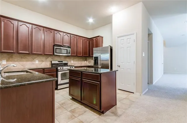 a kitchen with wooden cabinets and stainless steel appliances
