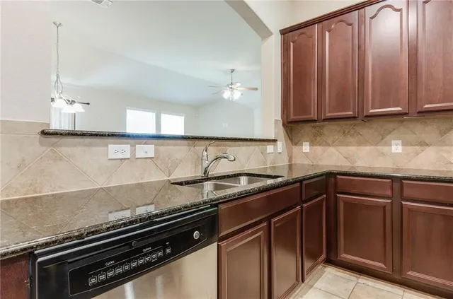 a kitchen with granite countertop a sink stove and cabinets