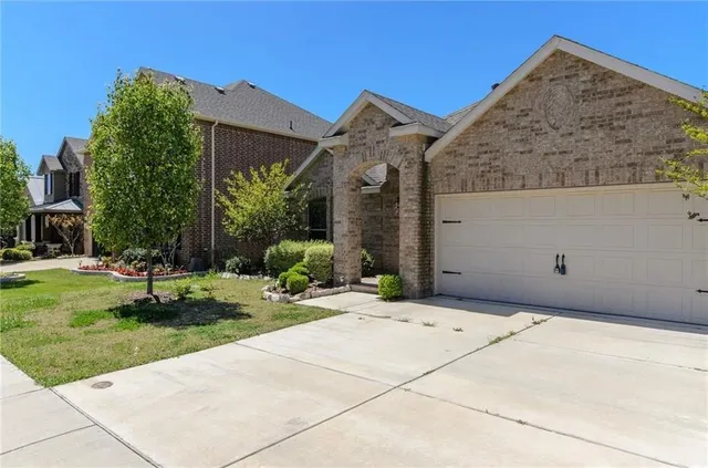 a backyard of a house with plants and palm trees