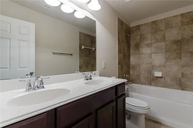 a bathroom with a double vanity sink toilet and a bathtub
