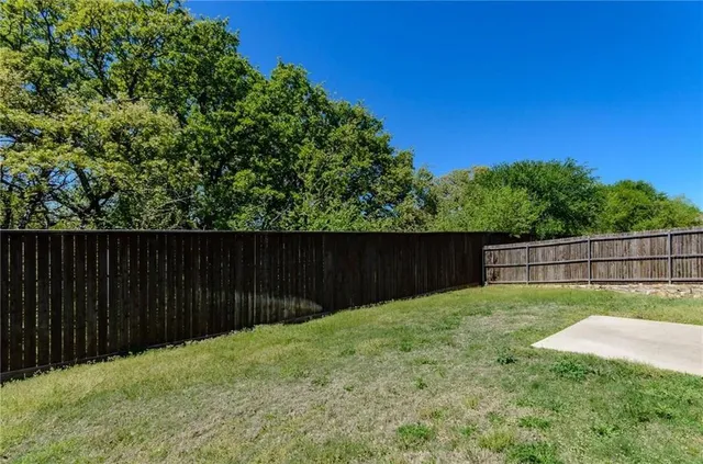 a view of backyard with wooden fence
