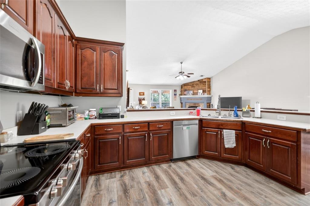 89 Katie Spring Lane Jefferson, GA 30549 - Photo 15 of 63 a kitchen with stainless steel appliances granite countertop a stove a sink dishwasher and a microwave oven with wooden cabinets