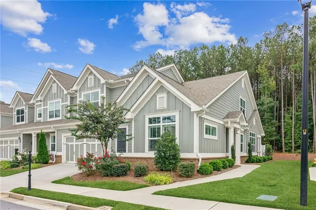 a front view of a house with a yard and trees