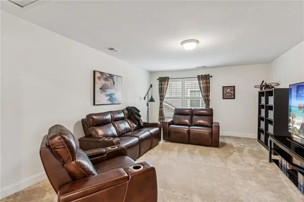 a living room with furniture a flat screen tv and a window