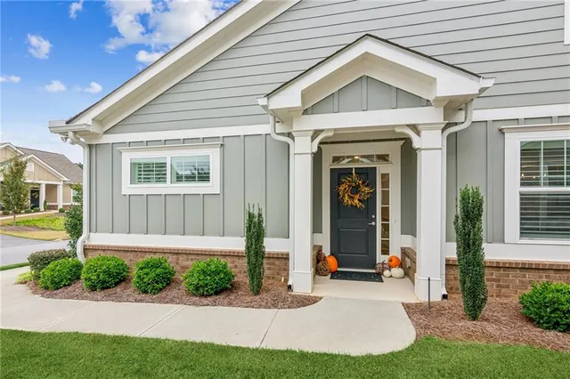 a front view of a house with a yard and potted plants