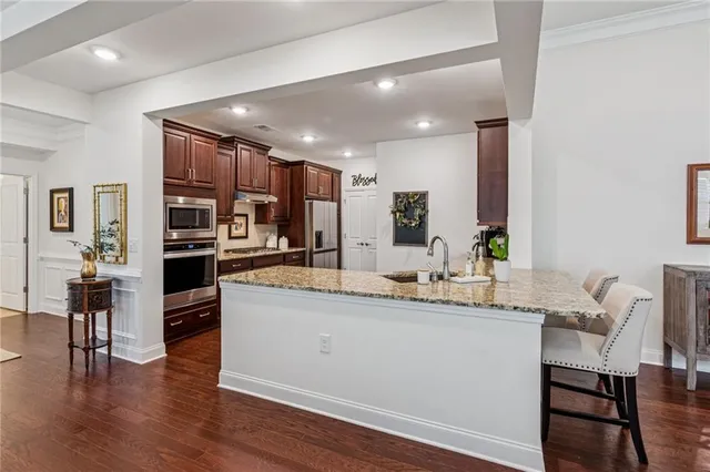 a large white kitchen with lots of counter space dining table and stainless steel appliances