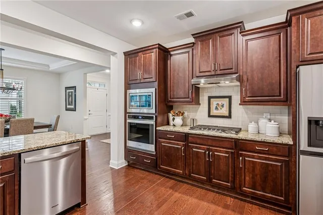 a kitchen with kitchen island granite countertop wooden cabinets and white appliances