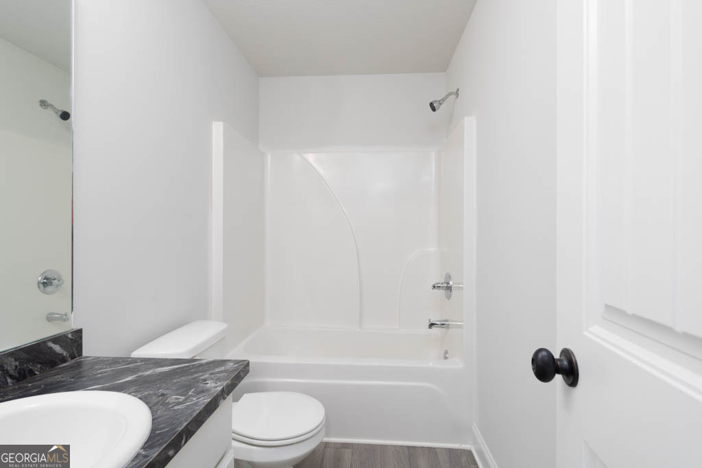 526 Oil Mill Road, Unit 9 Martin, GA 30557 - Photo 17 of 27 a bathroom with a granite countertop bathtub shower sink vanity mirror and toilet