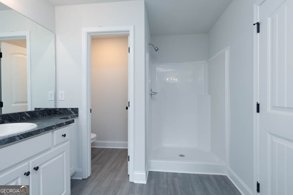 526 Oil Mill Road, Unit 9 Martin, GA 30557 - Photo 23 of 27 a bathroom with a granite countertop sink a toilet and shower