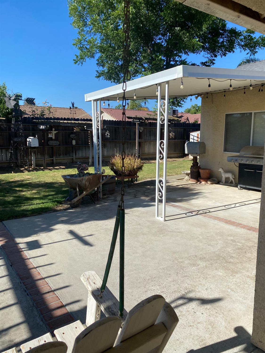 609 Merlot Avenue Madera, CA 93637 - Photo 39 of 45 a view of a patio with table and chairs a barbeque with wooden fence