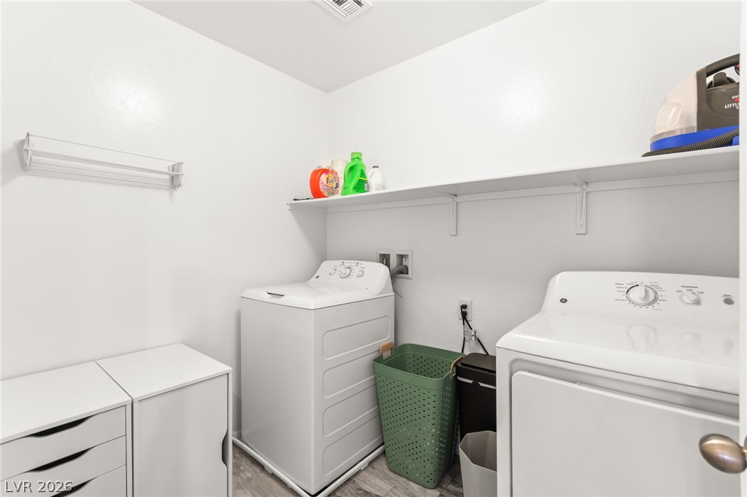 6435 Point Isabel Way Las Vegas, NV 89122 - Photo 33 of 57 Functional laundry space featuring a practical shelf for organization and durable vinyl flooring.