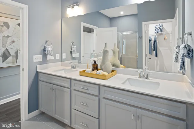 a bathroom with double vanity sinks and a mirror