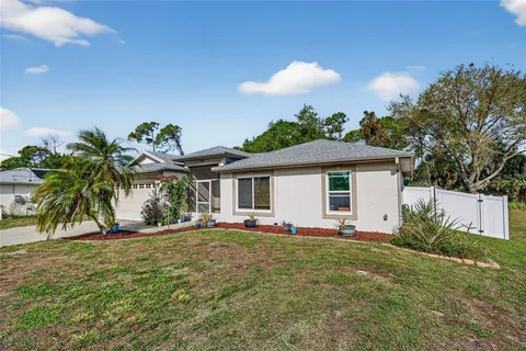 a front view of house with yard and trees in the background