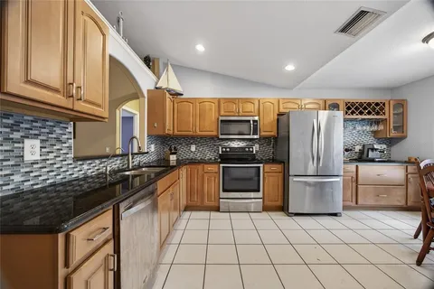 a kitchen with a sink a stove top oven and refrigerator