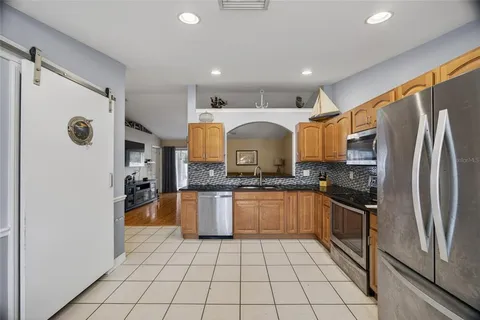 a kitchen with stainless steel appliances granite countertop a refrigerator and a sink