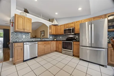 a kitchen with granite countertop a refrigerator stove top oven and sink
