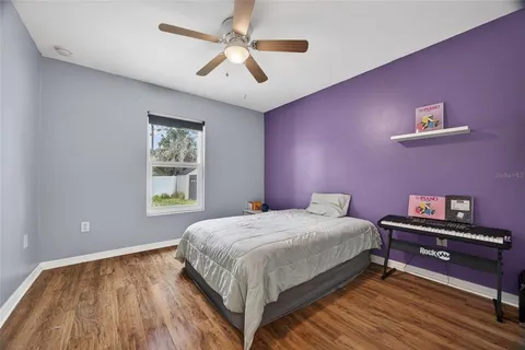 a bedroom with a bed chandelier and a window