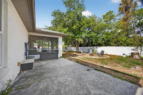 a view of backyard with swimming pool and seating space