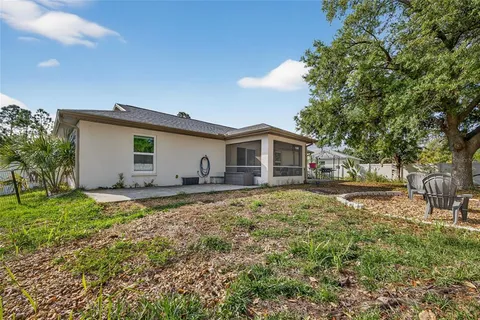 a view of a house with backyard and sitting area