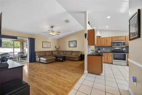 a large white kitchen with kitchen island granite countertop a large counter top stainless steel appliances and cabinets