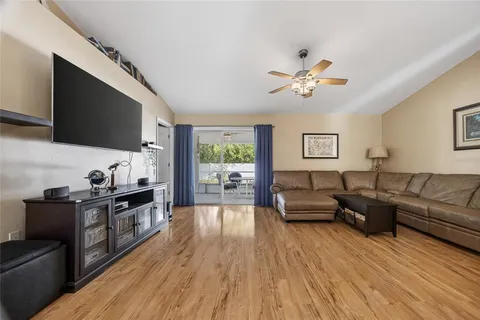 a living room with furniture flat screen tv and wooden floor