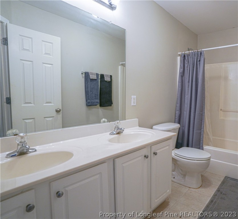 10 Pender Road Spring Lake, NC 28390 - Photo 22 of 30 a bathroom with a double vanity sink a toilet and a mirror
