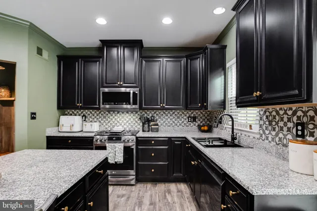 a kitchen with stainless steel appliances granite countertop wooden cabinets and a sink