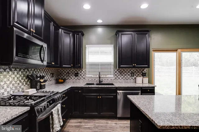 a kitchen with granite countertop stainless steel appliances and sink