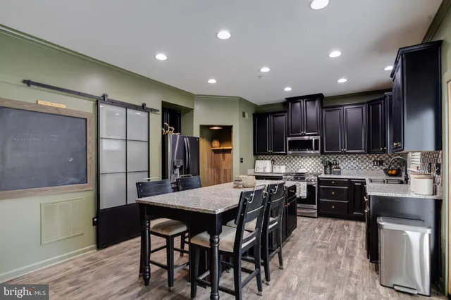 a kitchen with refrigerator a sink and chairs