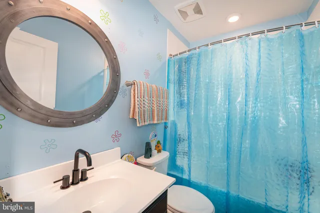 a bathroom with a sink mirror and toilet