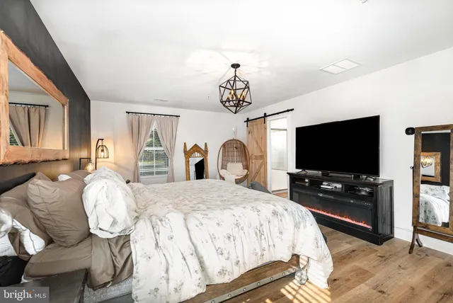 a spacious bedroom with a bed and a flat screen tv