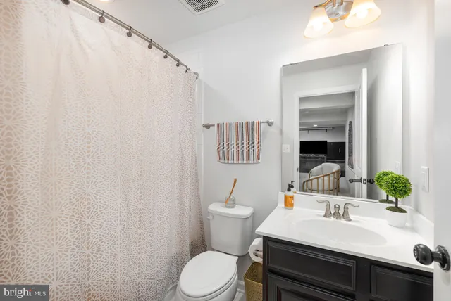 a bathroom with a sink a toilet and mirror