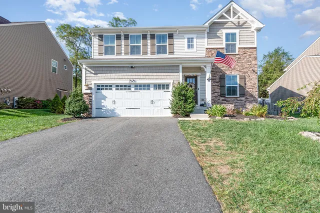 a front view of a house with a yard and potted plants