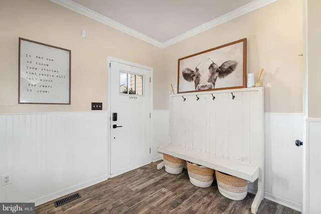 a view of room with wooden floor and paintings on the wall