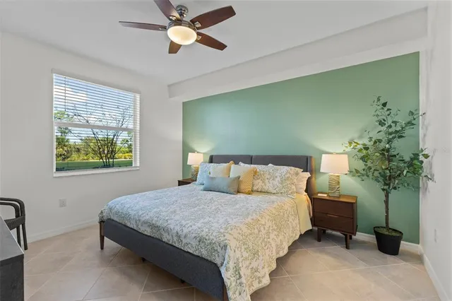 a bedroom with a bed table flowerpot and a window