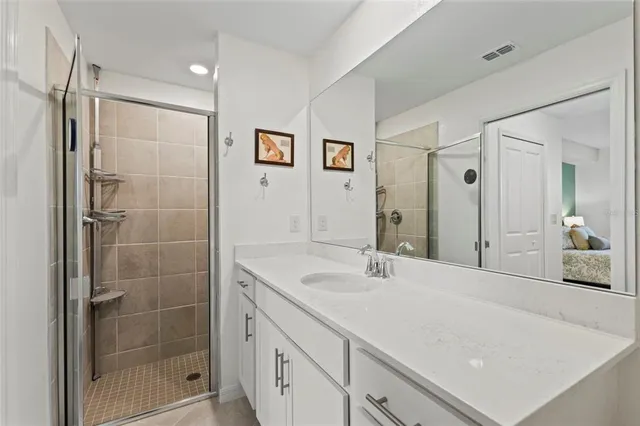 a bathroom with a shower sink and mirror