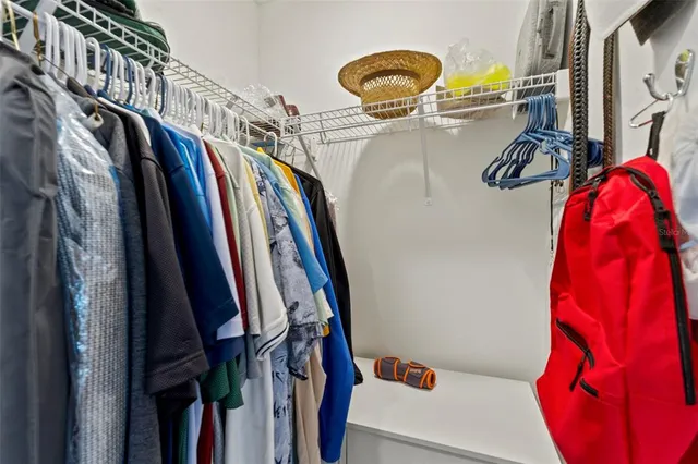 a view of walk in closet with clothes and shoes