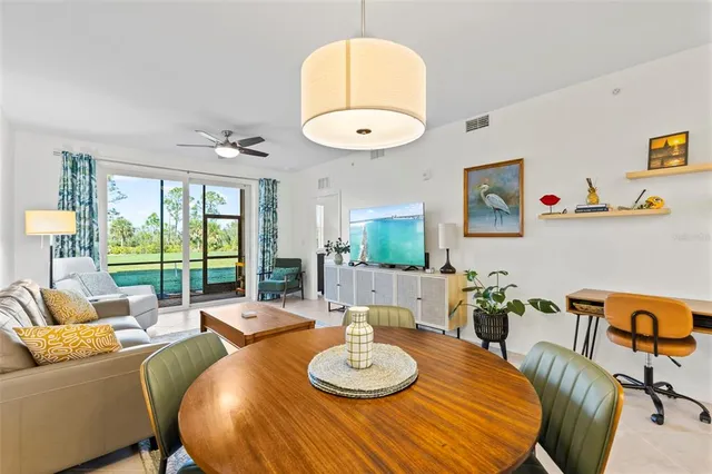 a living room with furniture a table and a large window