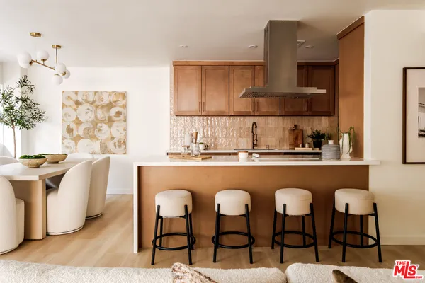 a kitchen with stainless steel appliances granite countertop a table chairs sink and cabinets