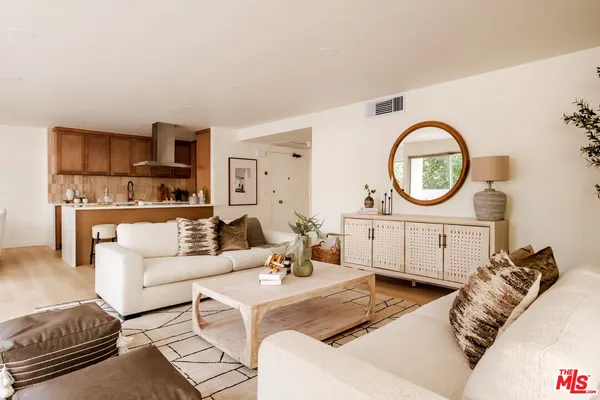 a living room with furniture a mirror and a clock