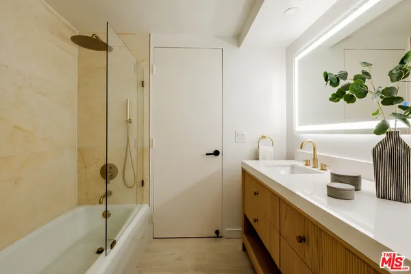 a bathroom with a tub sink and mirror