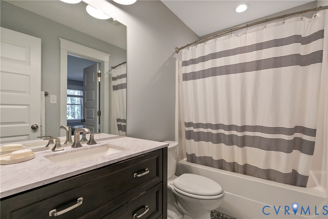 9749 Hoke Brady Road Henrico, VA 23231 - Photo 38 of 53 a bathroom with a sink a toilet a mirror and shower curtain